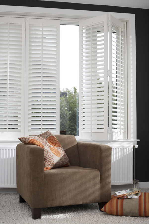 Shutters in woonkamer met bruine stoel