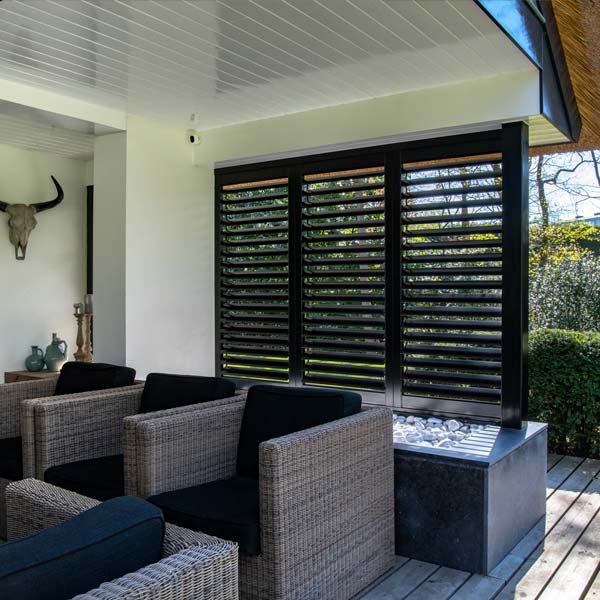 Zwarte buiten shutters in veranda met groene tuin