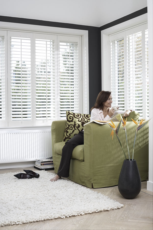 Shutters in woonkamer met groene stoel